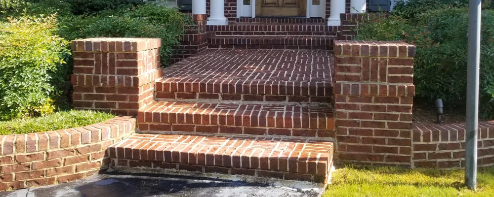 Concrete driveway and front walk, dark on the left and cleaned on the right (2018)