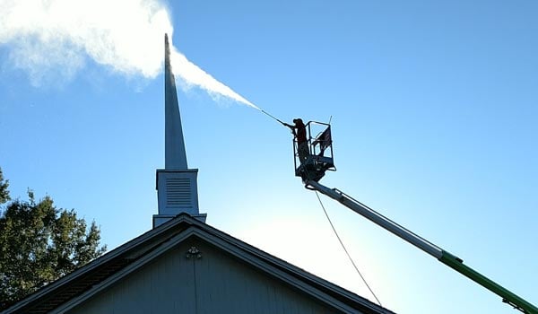 pressure washing worker cleaning chimney