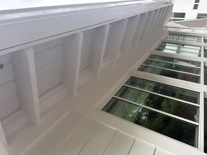 Bright white beamed soffit ceiling on enclosed porch after soft wash house washing in Marietta, GA