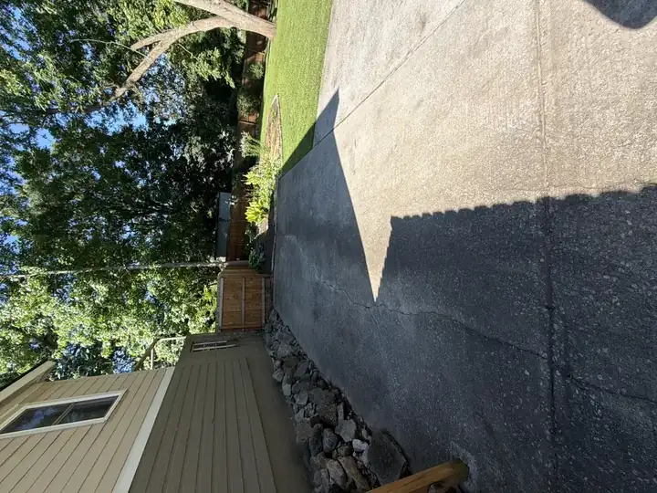 Side concrete driveway showing dark algae staining before pressure washing in East Point, GA