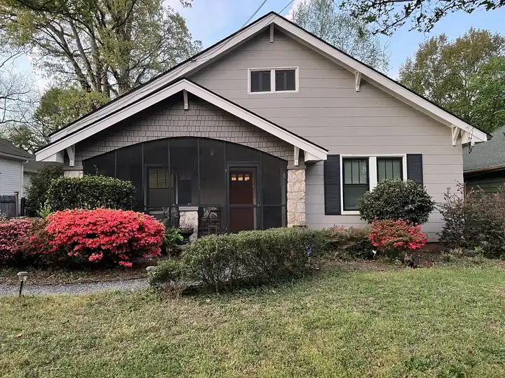 Craftsman bungalow with gray siding and screened porch before house washing service in East Point, GA