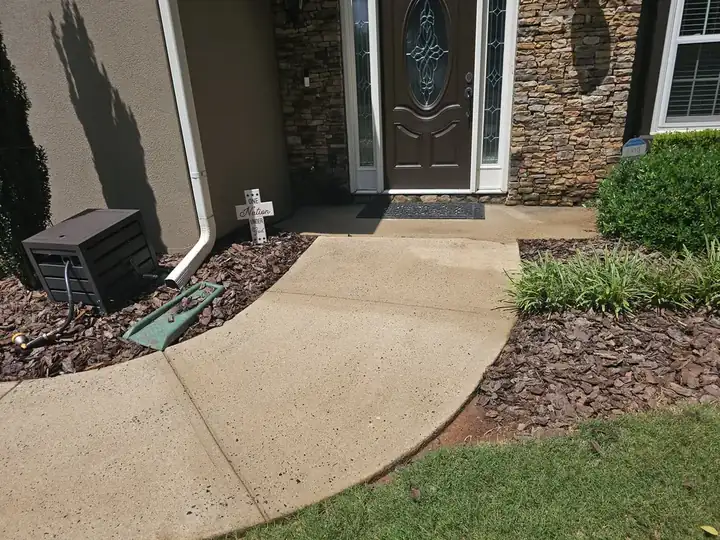 Concrete front entry walkway leading to front door at a residential home in Alpharetta, GA after pressure washing.