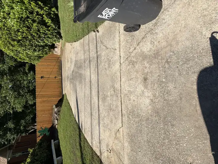 Concrete driveway with dark staining and grime before pressure washing service in East Point, GA