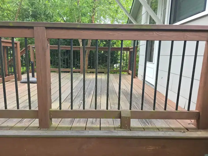 Weathered wood deck boards and railings with algae and mildew before pressure washing in East Point, GA