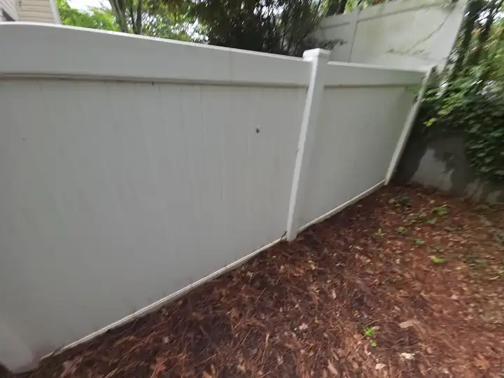 White vinyl privacy fence panels along a mulch bed at a fence cleaning job in Woodstock, GA.