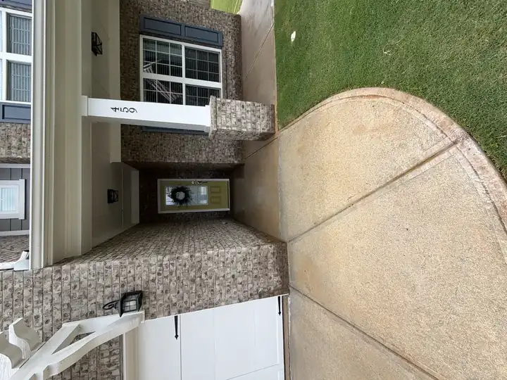 Concrete front porch walkway after pressure washing beside brick home exterior in Canton, GA