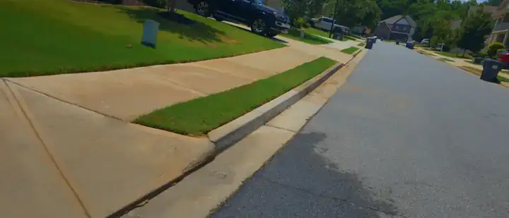 Concrete driveway apron and sidewalk at a residential home in Canton, GA after pressure washing.