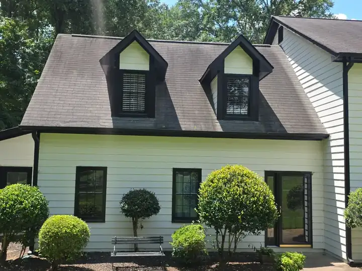 Front of a two-story white vinyl-sided home with asphalt shingle roof after a house wash in Canton, GA.