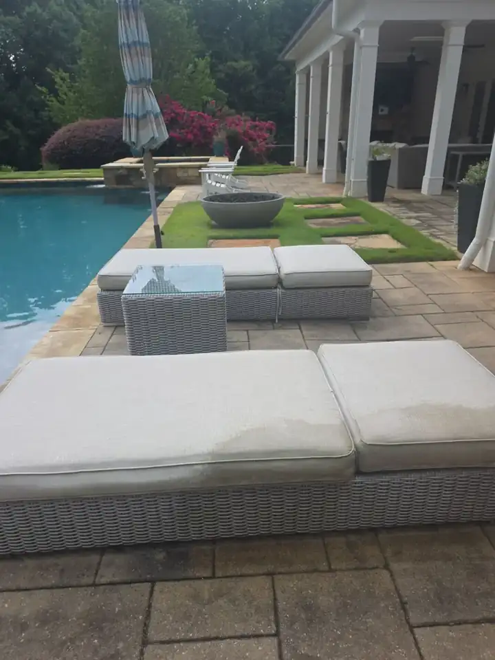 Wicker chaise lounges on a stone pool deck at a residential backyard in Milton, GA.