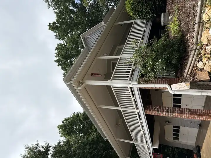 Clean front porch, white railing, and brick garage facade after house washing service in Canton, GA