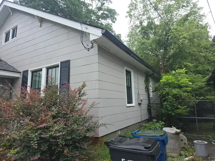 Clean gray vinyl siding on the rear corner of a craftsman home after house washing service in East Point, GA
