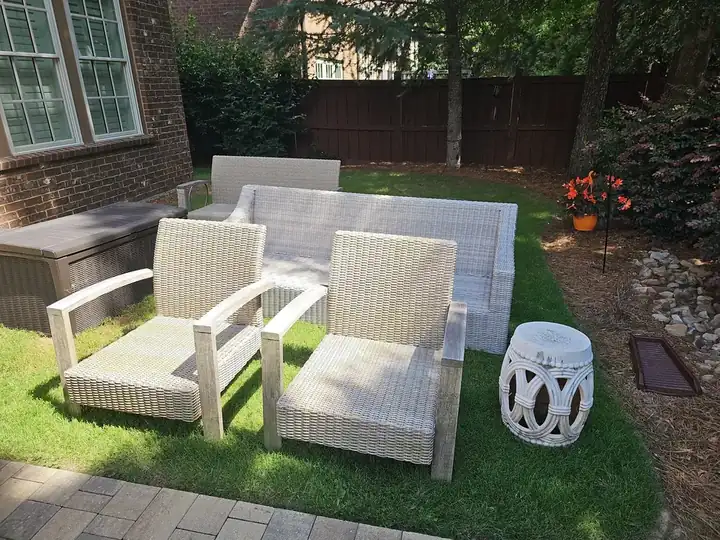 Wicker patio chairs and sofa moved onto the lawn during a pressure washing job at a Marietta, GA residence.