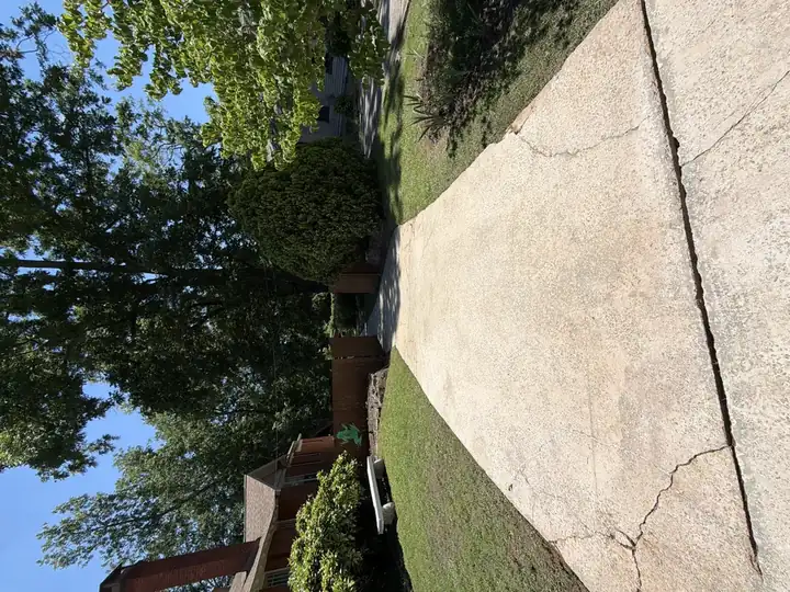 Front concrete driveway cleaned bright after pressure washing service in East Point, GA