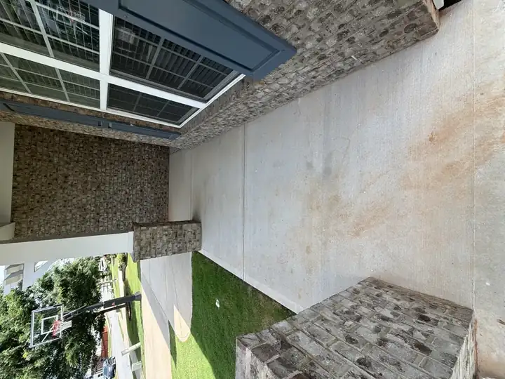 Concrete front porch pressure-washed clean beside brick columns in Canton, GA, with rust staining mostly removed
