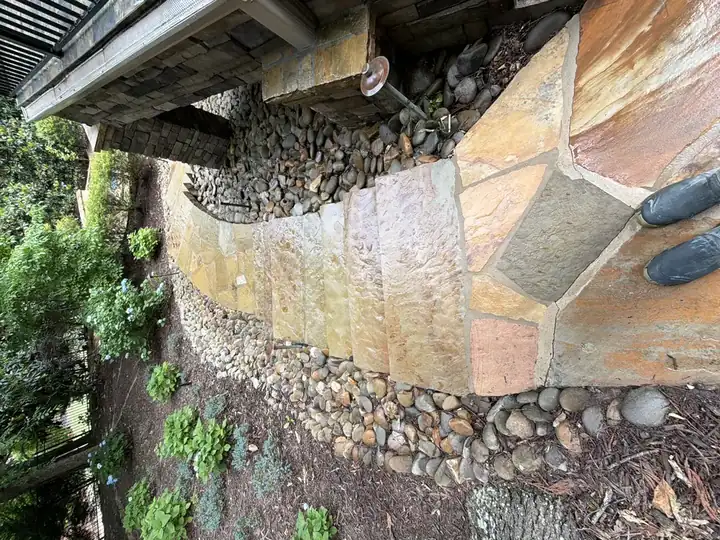 Flagstone path and steps with water actively running across the surface during pressure washing at a Duluth, GA home.