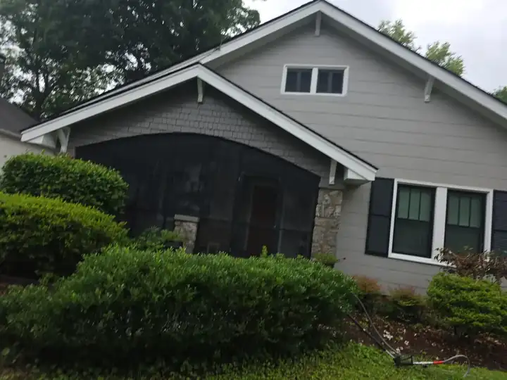 Gray vinyl siding and screened front porch on a craftsman-style home after house washing in East Point, GA