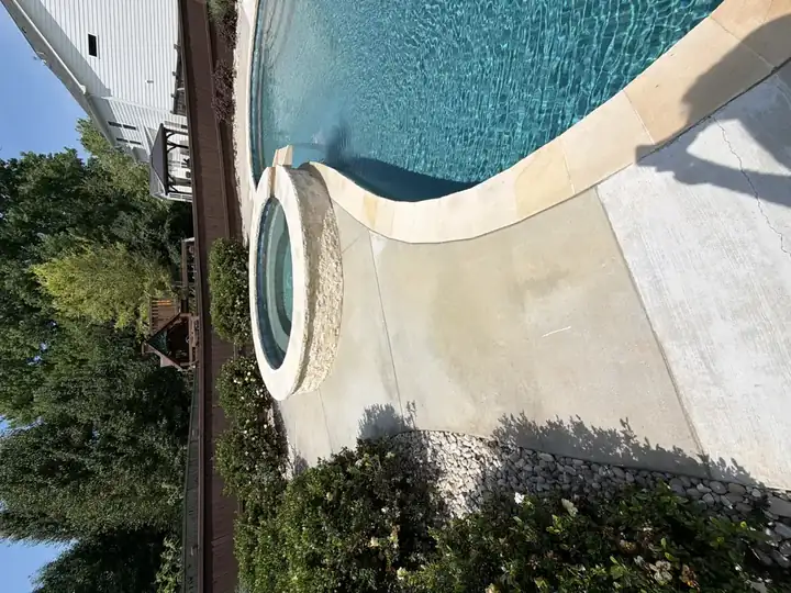 Pressure-washed concrete pool deck alongside raised spa and landscaping in Canton, GA residential backyard