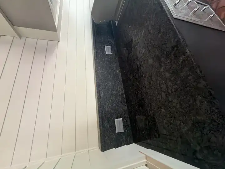 Dark granite outdoor kitchen countertop before cleaning in an enclosed porch area, Marietta, GA