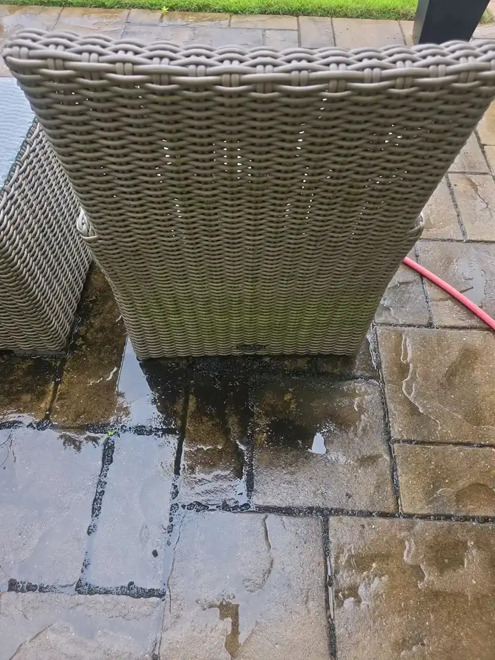 Close-up of wet stamped concrete pavers and a pressure-washing hose during pool deck cleaning at a Milton, GA home.
