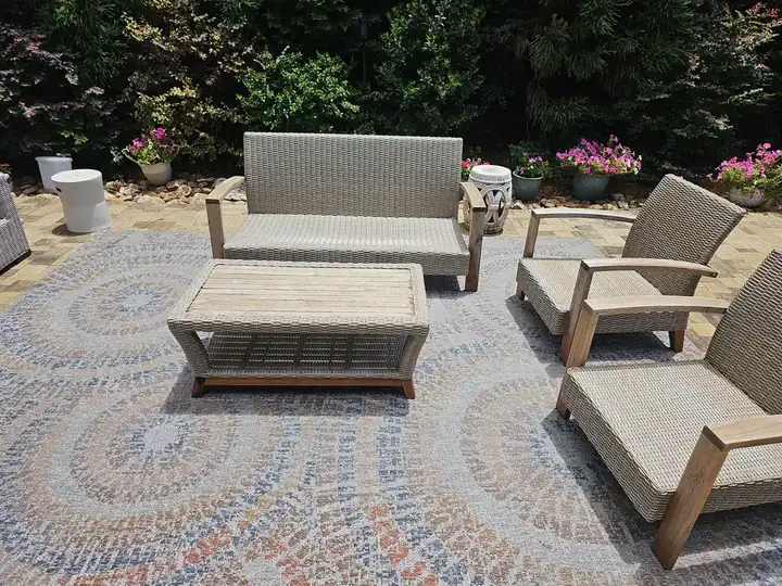 Wicker lounge set on a patterned outdoor rug over a paver patio at a Marietta, GA pressure washing job.