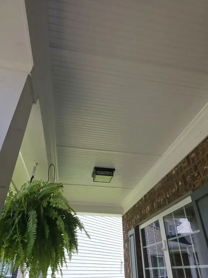 White beadboard porch ceiling with hanging fern and brick column at a Canton, GA home after a house wash.