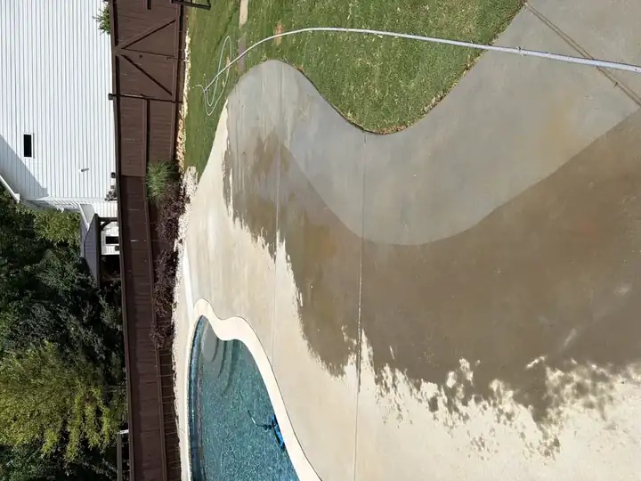 Concrete pool deck mid-clean during pressure washing in Canton, GA, showing half-cleaned surface beside the pool