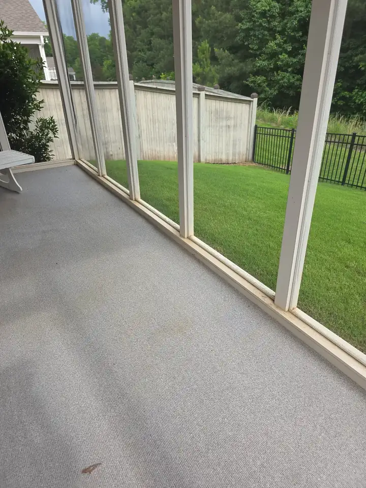 Interior floor of screened porch before cleaning in Woodstock, GA, showing surface staining and grime along base frames