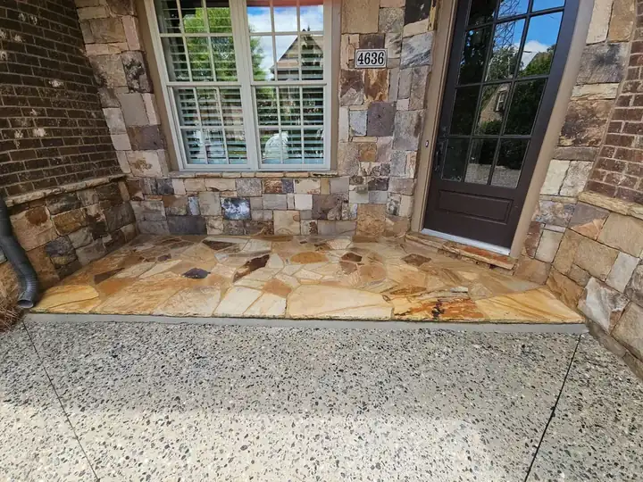Flagstone front porch and exposed aggregate concrete step at a residential pressure washing job in Marietta, GA.