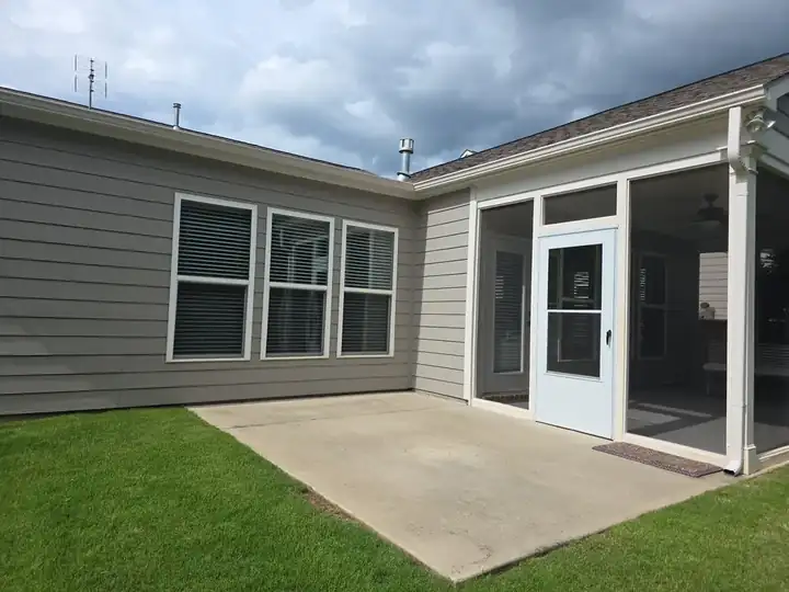 Concrete back patio and screened porch exterior before pressure washing in Woodstock, GA, showing surface grime ahead of listing