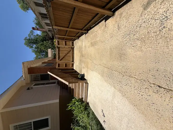 Narrow side concrete driveway cleaned after pressure washing with fence gate visible in East Point, GA