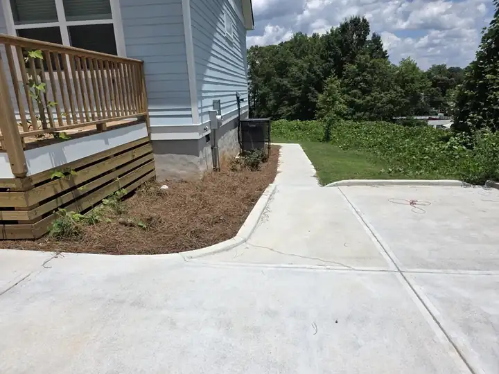 Concrete driveway and curved walkway beside a new construction home after pressure washing in Atlanta, GA.