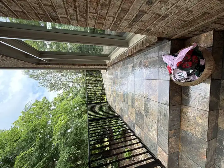Narrow tile balcony with iron railing overlooking the yard at a Duluth, GA home during a pressure washing job.