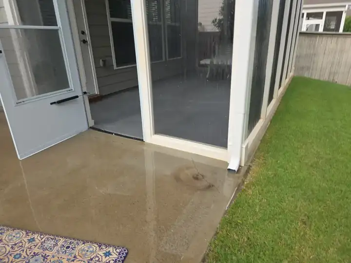 Freshly pressure-washed concrete patio next to screened porch in Woodstock, GA, surface clean and still wet after service
