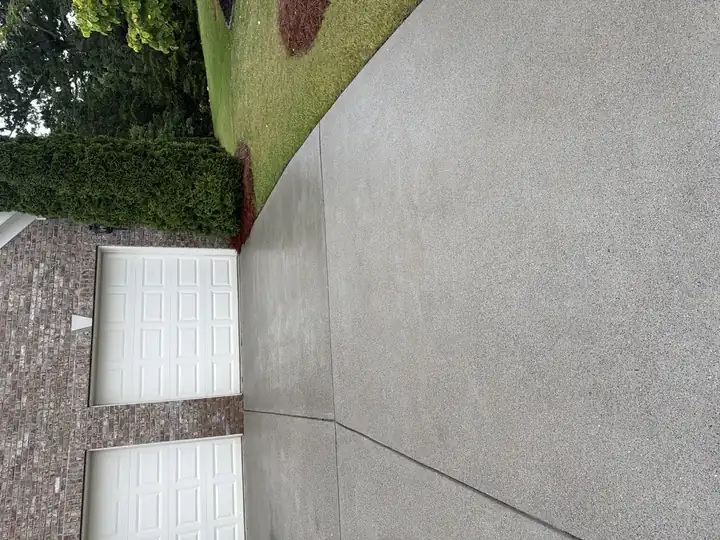 Clean concrete driveway after pressure washing in Cumming, GA, close-up near garage showing uniform gray surface