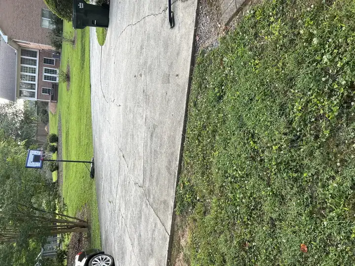 Wide concrete driveway with cracking and surface discoloration before pressure washing at a Canton, GA home.