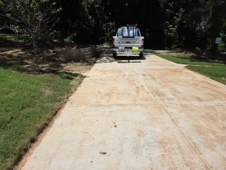 Alpha Pressure Washing truck and trailer on a concrete driveway at a new construction wash job in Atlanta, GA.