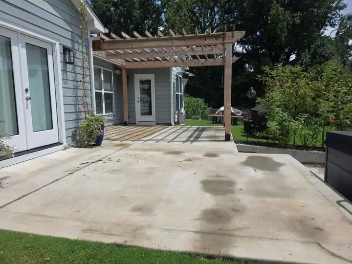 Concrete backyard patio under a wood pergola at a residential pressure washing job in Canton, GA.