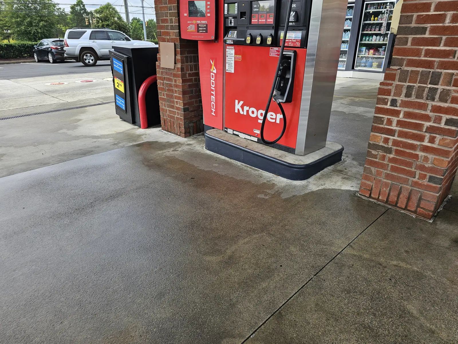Kroger fuel-pump island concrete, cleaned section beside concrete still dark, Dallas Highway, Due West, Cobb County, GA (Aug 2024)